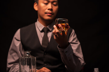 Business man bartender pours whiskey into a glass, sitting sadly in a restaurant	
