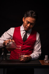 Bartender is pouring whiskey into a glass in a restaurant	