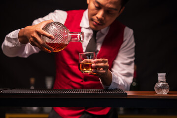 Bartender is pouring whiskey into a glass in a restaurant	