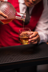 Bartender is pouring whiskey into a glass in a restaurant	