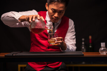 Bartender is pouring whiskey into a glass in a restaurant	