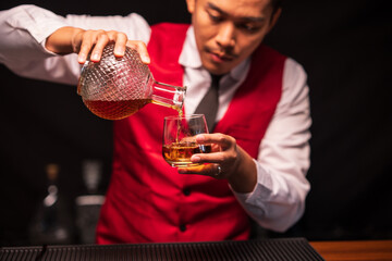 Bartender is pouring whiskey into a glass in a restaurant	