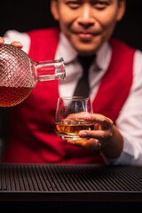 Bartender is pouring whiskey into a glass in a restaurant	