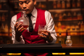 Bartender is pouring whiskey into a glass in a restaurant	