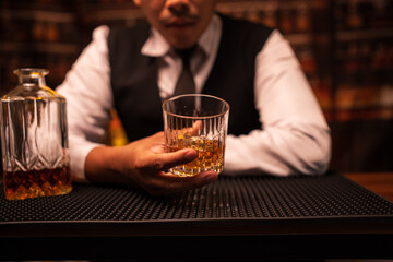 Bartender is pouring whiskey into a glass in a restaurant	