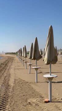 Jesolo, vento in spiaggia con ombrelloni chiari