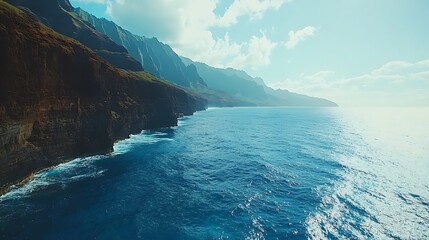 Rugged Cliffs Meet Serene Ocean Under a Light Blue Sky with Clouds