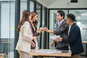 Group of businesspeople are standing in a meeting, exchanging knowledge in the office.
