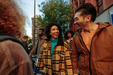Group of young tourists walking down the street and having fun