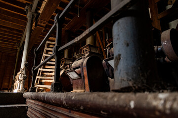 Industrial machinery displayed in a historical workshop with wooden beams and intricate details