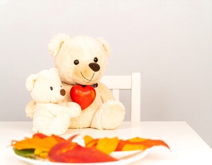 Two teddy bears holding a heart on a white table
