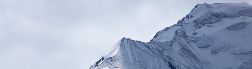 A close-up of a mountain peak in bad weather, leading to the death of climbers in windy weather, snow-capped peaks in the clouds