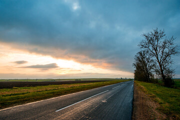 a colorful yellow sunrise over an empty highway in Belarus