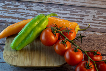 tomatoes on a wooden table. fresh tomatoes and peppers on rustic board