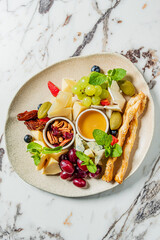 A stunning assortment of cheeses, grapes, and nuts is artfully arranged on a light marble surface