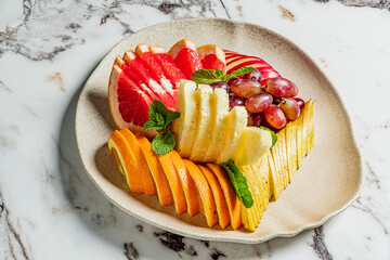 A colorful array of fresh fruits, including pineapple, grapes, and apples, beautifully arranged