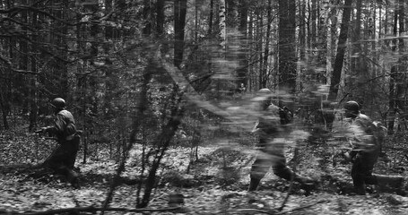 Historical Re-enactment Black And White . American Soldiers Of USA Infantry Of World War II Marching Running Run Along Forest In Autumn Spring Day. Group of soldiers