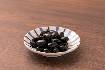 A traditional dish made for Japanese New Year's celebrations. Boiled black beans.正月などに作られる日本の伝統的な料理。黒豆の煮豆。