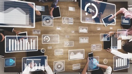 A diverse team engages in a collaborative office meeting, utilizing digital tools and devices to analyze data and discuss strategies with vibrant graphs and visuals. Xenic - Powered by Adobe