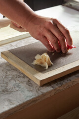 Sushi Chef Serving Maguro Nigiri on Stone Plate