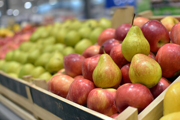 Fresh pears and apples displayed in grocery store produce section