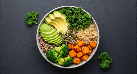 Healthy vegan buddha bowl with quinoa, broccoli, sweet potato, avocado, and kale on a dark background