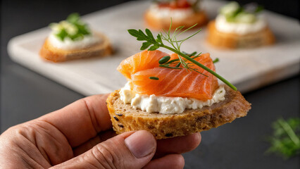 canapes with red fish and cucumber in hand