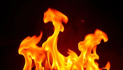 Fototapeta premium Intense orange and yellow flames burning against a dark background, wallpaper, fire pit