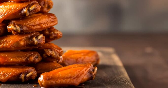 Deliciously stacked spicy chicken wings on a rustic wooden surface