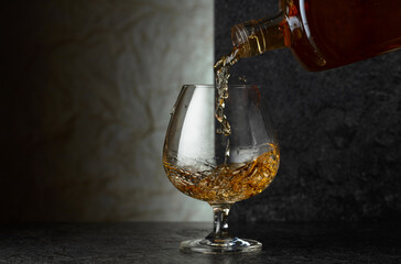 Pouring brandy from a bottle into a glass.