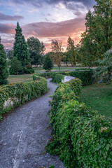 Yamaguchi park Garden at Sunset in Pamplona, Navarre, Spain. Curved Pathway with Trimmed Hedges, Green Landscape, Peaceful Setting