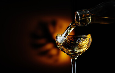 Rum being poured from a bottle into a glass.