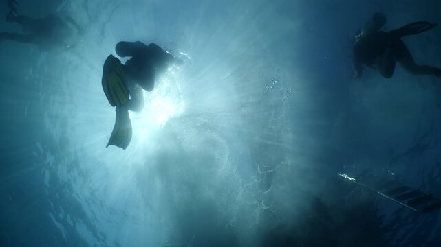 scubadiver scenery ascending to the surface with sun beams and rays underwater