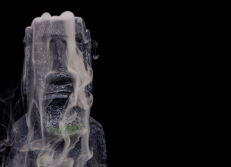 Fototapeta premium Easter island heads still life with strange swirling smoke and mist handmade by photographer from silicon moulds and garden rocks