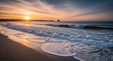 Obraz premium Vibrant sunset over a sandy beach with foamy ocean waves and distant rocky formations