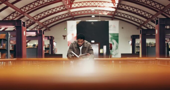 Student, man and reading a book in library for exam preparation, study insight and test knowledge. University, person and course resources on campus for thesis citation, PHD research and education