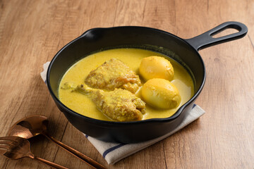 Opor Ayam and egg boiled, Indonesian traditional food served in white bowl, made from chicken cooked with coconut milk and spices. Its served to celebrate Eid Adha and Eid Fitr.