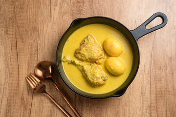 Opor Ayam and egg boiled, Indonesian traditional food served in white bowl, made from chicken cooked with coconut milk and spices. Its served to celebrate Eid Adha and Eid Fitr.