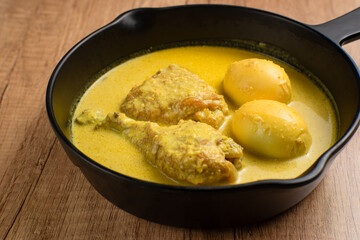 Opor Ayam and egg boiled, Indonesian traditional food served in white bowl, made from chicken cooked with coconut milk and spices. Its served to celebrate Eid Adha and Eid Fitr.