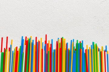 Heap of colorful plastic drinking straws on Colored background, flat lay. Copy Space for text