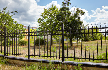 Metal fence in the city park. Decorative black iron guardrail for protection, close up