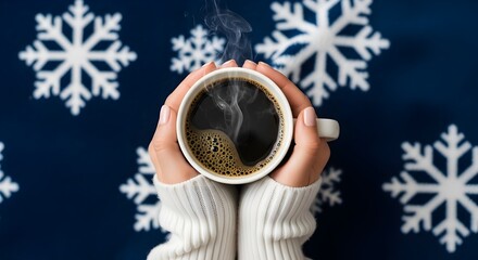 Woman's hands in white sweater holding steaming hot coffee cup on winter snowflake background