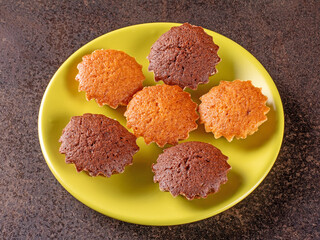 Delicious chocolate and lemon mini muffins on a bright green plate from above