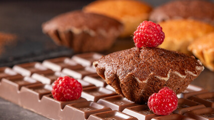 Close-up view of delicious muffins topped with raspberries and chocolate
