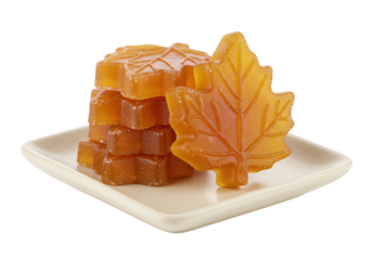Isolated maple leaf candy, sugar cubes on a square dish, amber-colored maple candy sweets, close-up