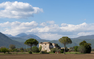 Obraz premium Abandoned farmhouse stands against a mountain backdrop