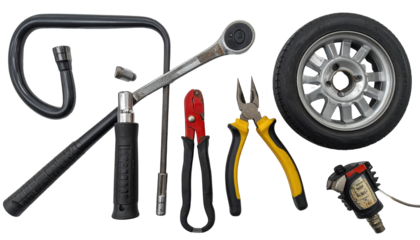 Various automotive tools, including a tire and a set of wrenches, are meticulously arranged against a stark black background.