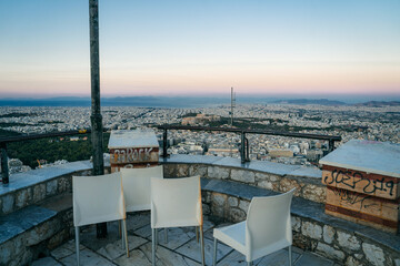 Scenic view of the bell tower of Saint George Church on Lycabettus Hill in Athens, Greece. The stone tower stands on the hilltop with a panoramic view of the Greek capital spreading into the distance