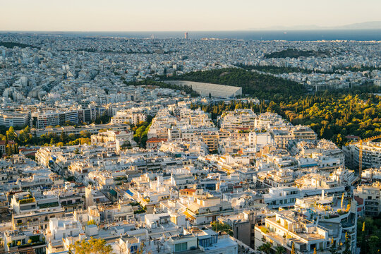 Fototapeta Panoramic view of Athens, Greece from the top of Lycabettus Hill at sunset. The Acropolis can be seen in the distance with the urban sprawl of the Greek capital spreading toward the horizon. White