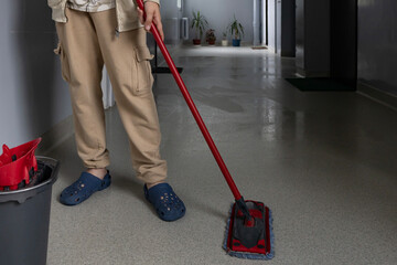 Cleaning a hallway with a mop and bucket in a cozy indoor space during daytime
